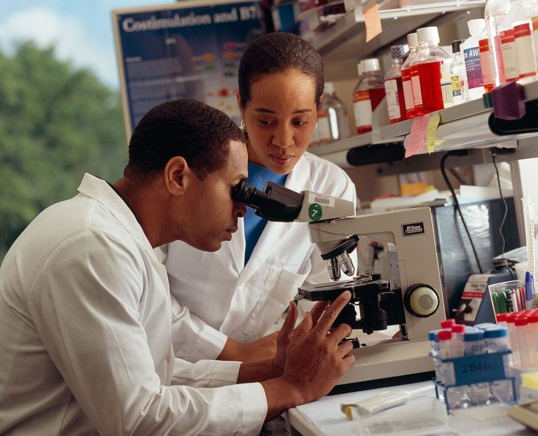 A researcher looking through a microscope in a laboratory