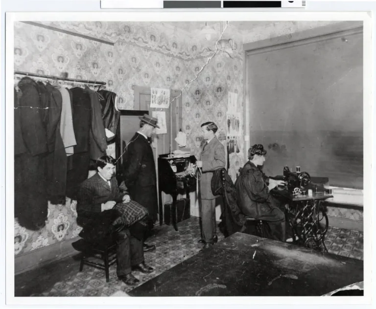 A tailor shop owner serving a customer in a small business.